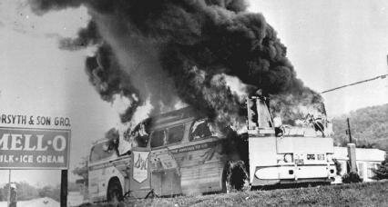 A Freedom Rider bus goes up in flames after a fire bomb was tossed through a window in 1961 in Alabama. AP Images.