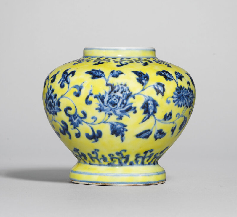 A rare blue and white ‘floral scroll’ jar, Xuande six-character mark in underglaze blue within a double circle and of the period (1426-1435), yellow enamel later