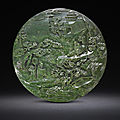 A rare spinach-green jade 'laozi passing through the hangu pass' double-sided circular screen, early 19th century
