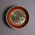 Porcelain lion dogs dishes with green enamel reserved on a red ground, ming dynasty, jiajing mark and period (1522-1566)