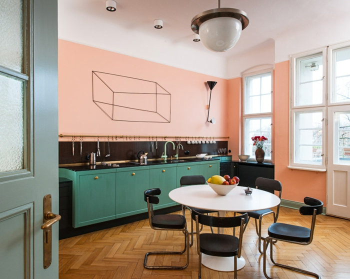 cuisine-couleur-rose-saumon-sol-en-bois-table-ronde-blanche-chaises-modernes-armoires-de-cuisine-bleu-vert-déco-cuisine-minimaliste
